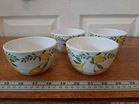 Four lemon-themed bowls side by side with ruler for scale