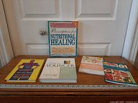 All four books on tabletop with ruler for scale