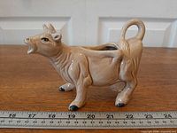 Side profile of cow creamer with ruler indicating length and height