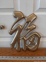 Front view of solid brass Chinese “Fu” wall hanging