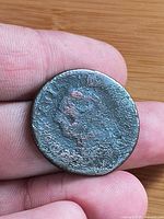 Obverse side showing worn portrait on copper coin