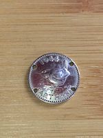 Reverse side with wren and date 1944, four holes visible