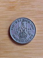 Reverse of 1948 one shilling coin showing crowned lion, date and denomination