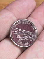 Reverse of coin with airplane design and date