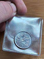 Reverse of coin showing hockey player inside poly holder