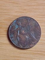 Reverse side with Britannia figure visible, corrosion and toning evident