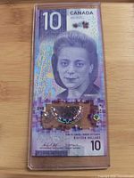 Front of Canadian $10 Viola Desmond note inside clear holder