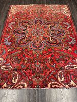 Full view of the entire Persian rug on dark floor