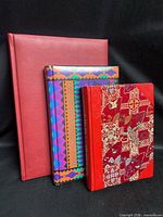 Front view of three notebooks standing upright showing sizes and cover styles