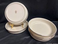 Five identical Lenox ivory bowls, one upright on stand showing underside mark, platinum rims visible