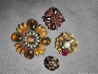 Front view of all four brooches showing stones and designs