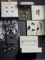 Overview of all boxed and carded jewelry pieces on black background