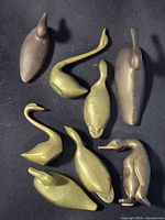 group shot of eight brass duck figurines
