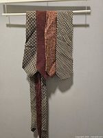 Four Donna Karan ties hanging to show full length and patterns