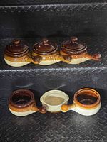 Three lidded bowls on top step, two unlidded bowls below