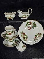 Full set showing cups, saucers, dessert plate, sugar bowl, creamer and teapot lid