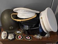 Group shot of helmet, hats, belt, badges and buckles