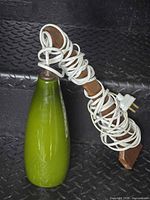 Full view of green glass shade, wood stem, coiled white cord and plug