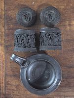 Pair of carved resin lidded candle containers and pottery chamber holder top view