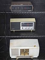 All three radios stacked: top Panasonic clock radio, middle Panasonic table radio, bottom GE clock radio