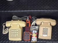 Group shot of two beige push-button phones, orange butt phone, packaged rotary dimmer