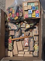 Overview of box showing unfinished blocks, alphabet cubes, bead bag, puzzle cut-outs