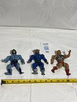 All three action figures with tape measure for scale