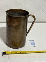 Full view of copper pitcher with handle and lot card