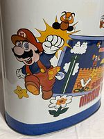Close-up of Mario and Goomba artwork on can