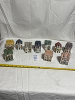 Group of 10 ceramic house spice jars with tape measure for scale