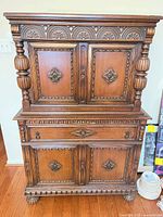 Front view of carved wooden buffet/hutch showing upper and lower cabinets and drawer