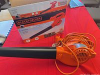 Blower with nozzle, extension cord wrapped around body, original box visible