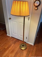 Full view of brass floor lamp with shade