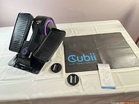 Full lot showing Cubii machine, mat, wheel stoppers, manual