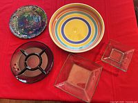 All five glass serving pieces arranged on red cloth
