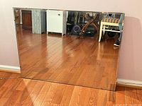 front view of large frameless mirror leaning against wall