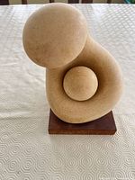Front view of abstract mother and child sculpture on wood base