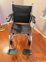 Front view of Drive Fly-Weight folding transport wheelchair showing seat, armrests, footrests and wheels