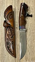 Knife and sheath side by side on wood surface