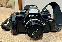 Front view of Nikon N2000 with attached lens, cap, and strap