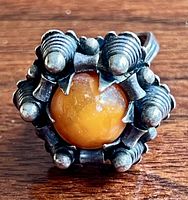 Front view showing amber cabochon and sculptural silver finial setting
