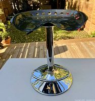 Full view of stool showing tractor seat and chrome pedestal