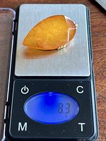 Brooch on digital scale displaying 8.3 g