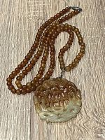 Full view of bead necklace and carved jade pendant