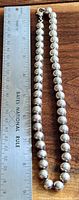 Full necklace beside ruler showing length and bead size