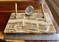 Top view showing marble base, two pens, clock and nameplate with ruler for scale