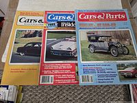 Three magazines showing covers: Shelby GT 500-KR, 1908 Model S Touring, Cartier Calais interior