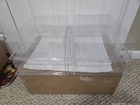 Four clear plastic display cases stacked