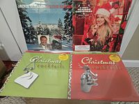 Four albums including Jackie Gleason, Meghan Trainor, and two Christmas Cocktails volumes shown front covers in shrink wrap
