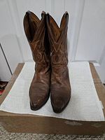 Front view of brown leather cowboy boots standing upright